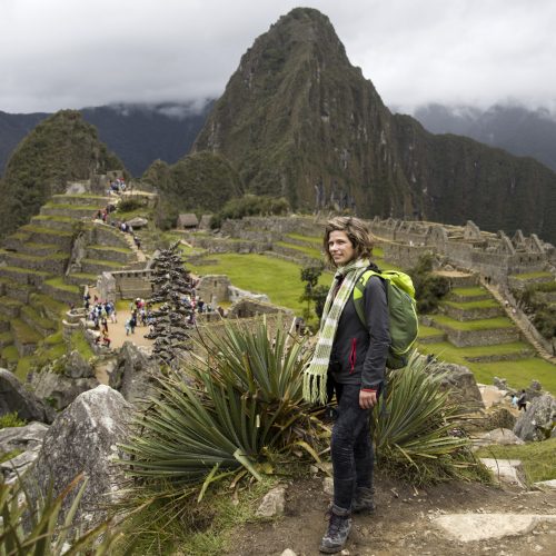 Young woman standing above Machu Picchu Inca citadel in Peru