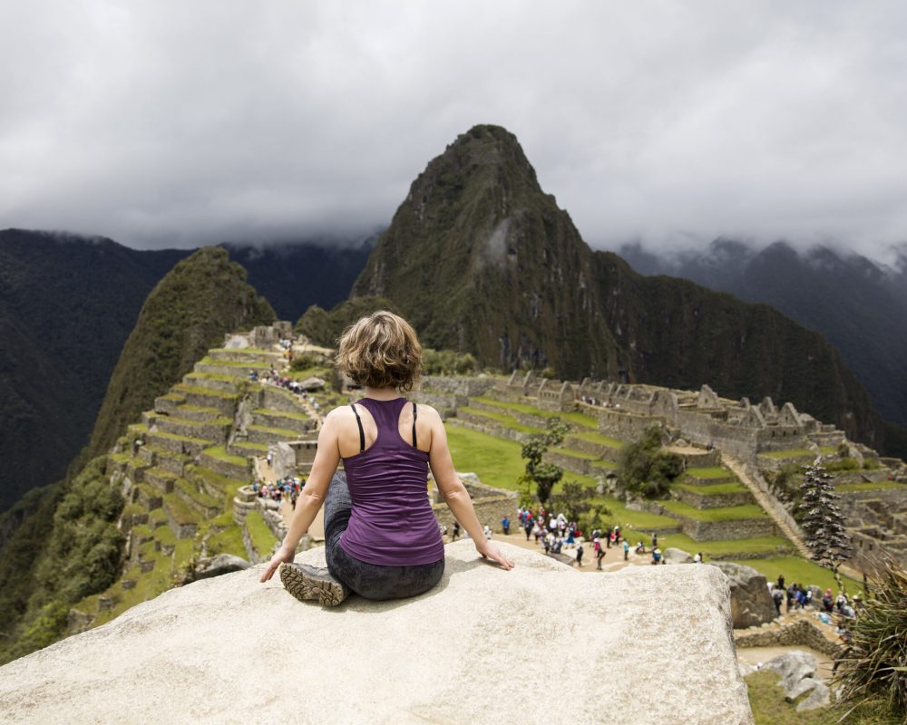 Machu Picchu in Peru Young woman meditating above Machu Picchu Inca citadel in Peru