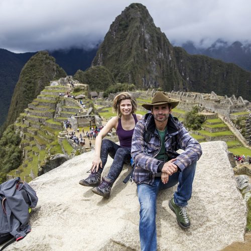 View at young couple at Machu Picchu Inca ruins in Peru